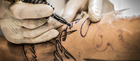 Person som tatuerar någons arm