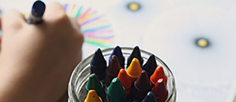 Ett barn som ritar med färgglada kritor