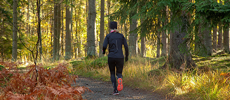En kvinna joggar i skogen