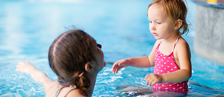 Kvinna och barn badar i simhallen