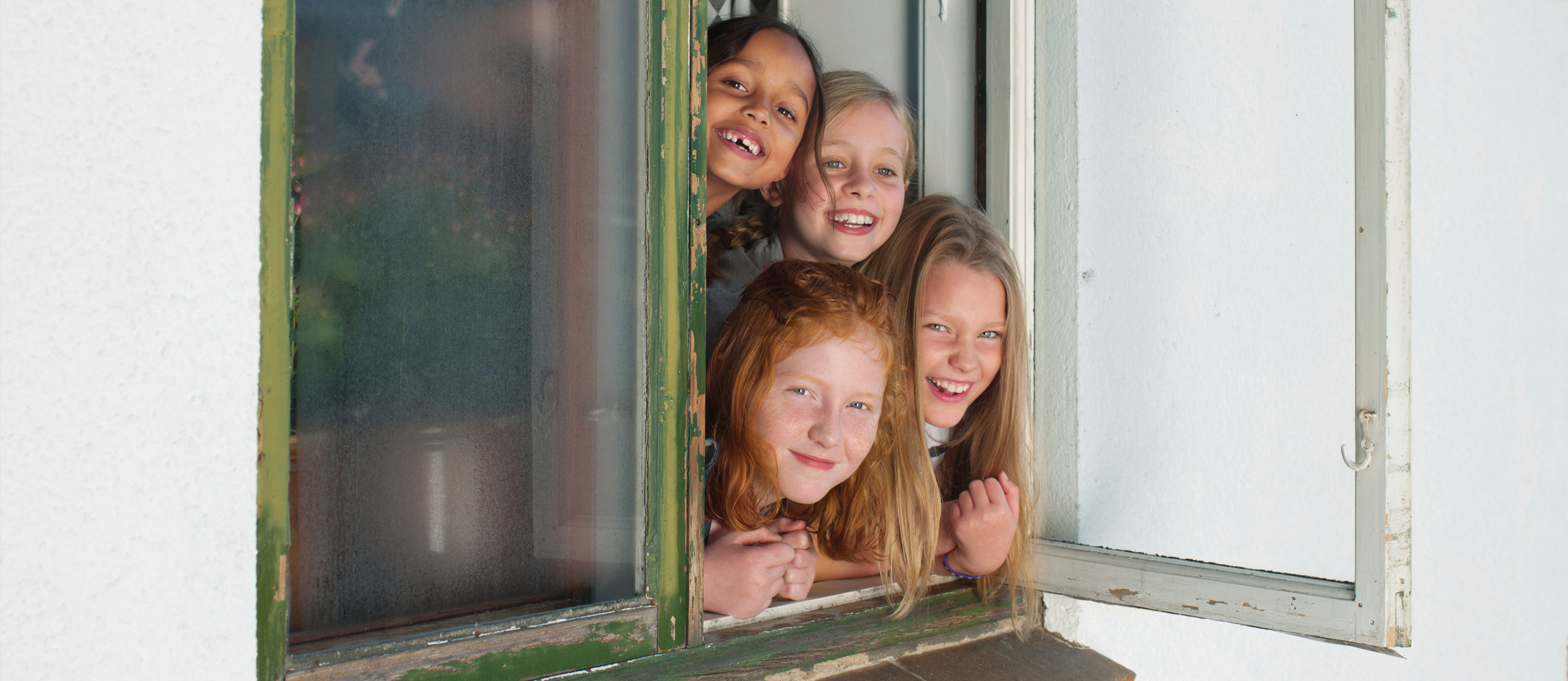 Barn tittar ut genom ett fönster